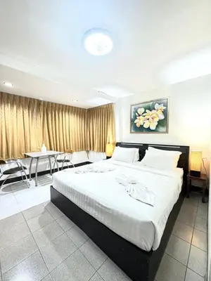 a bedroom with a large bed and a dining room at La Casa Patong in Patong Beach