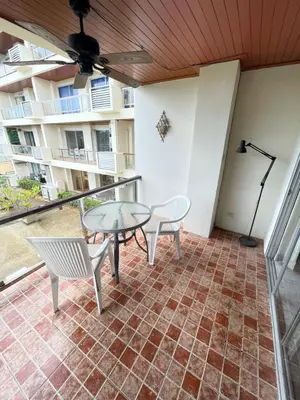a patio with a table and chairs and a balcony at Rawai apartments in Ban Saiyuan (1)