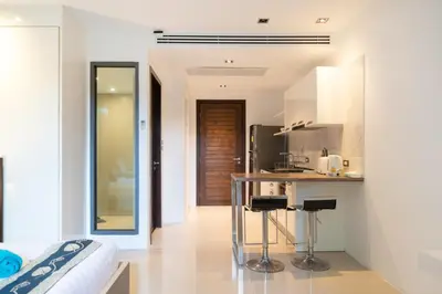 a kitchen with a counter and a bar with stools at Studio Apartment - Emerald Terrace Patong in Patong Beach