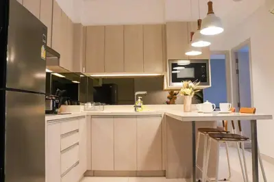 a kitchen with a stainless steel refrigerator and white cabinets at Cassia Residences Sea View in Laguna Phuket