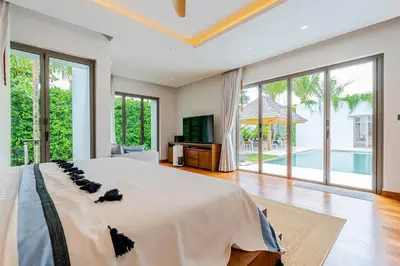 a bedroom with a large bed and a tv at Stylish Pool Villa Tropical Hideaway in Ban Phru Champa