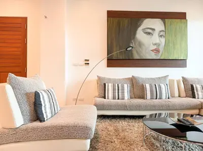 a living room with two couches and a painting of a woman at Kamala Falls A3-4 IBG Property in Kamala Beach