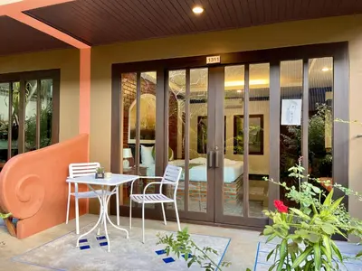 a patio with a table and chairs in front of a building at Fullmoon Beachresort Krabi in Ao Nang Beach