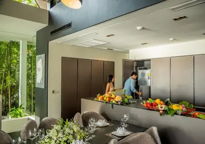 a man and a woman preparing food in a kitchen at Villa Yin, Private Oceanfront Villa, Kamala Beach in Kamala Beach