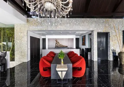 a dining room with red chairs and a chandelier at Villa Yin, Private Oceanfront Villa, Kamala Beach in Kamala Beach