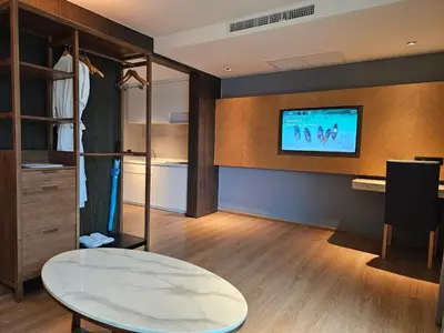a room with a table and a tv on a wall at La Vita Luxury Apartment in Rawai Beach