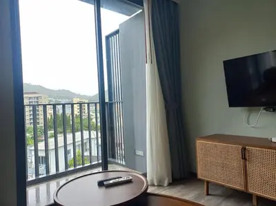 a living room with a large window with a view of a building at The Deck Patong 7Fl Mountain View2 in Patong Beach