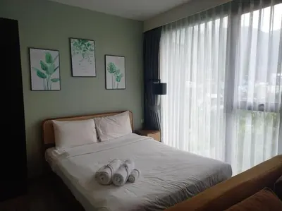 a bedroom with a bed with two pairs of shoes on it at The Deck Patong 7Fl Mountain View2 in Patong Beach