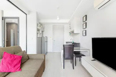 a living room with a couch and a flat screen tv at 6th Avenue Surin Condomium in Surin Beach