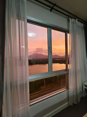 a window with a view of a sunset at D-Condo Mine Kathu in Ban Ket Ho