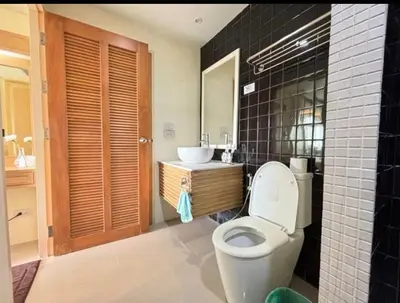 a bathroom with a toilet and a sink at มัณดาวีต์ คอนโดa in Ban Khlong Son