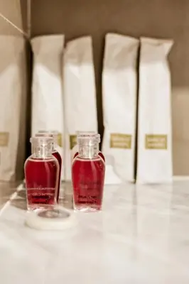 two bottles of red liquids sitting on a table at Suite Marella 1BR Pools Shuttle to Nai Harn in Rawai Beach