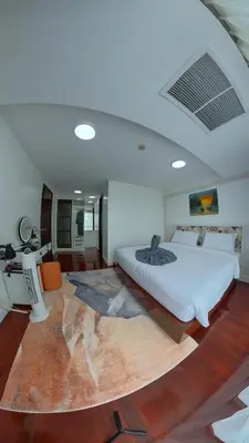 a bedroom with a large white bed and a rug at The Kris Cozy 2-Bedrooms Apartment in Patong Beach
