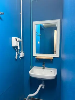 a blue bathroom with a sink and a mirror at Blue Horizon Hostel By Blue Flow in Phi Phi Don