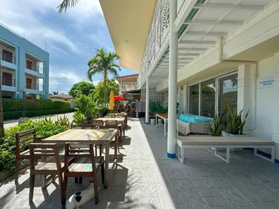 a patio with wooden tables and chairs on a building at Blue Horizon Hostel By Blue Flow in Phi Phi Don