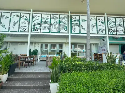 a building with a balcony with tables and chairs at Blue Horizon Hostel By Blue Flow in Phi Phi Don