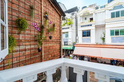 a brick wall with flowers on the side of a building at Sweett Lemon Hostel in Patong Beach