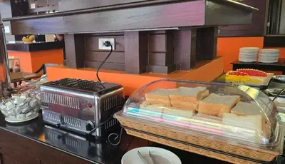 a counter with a tray of cheese and aasser at Rattana Karon Beach Hotel in Karon Beach