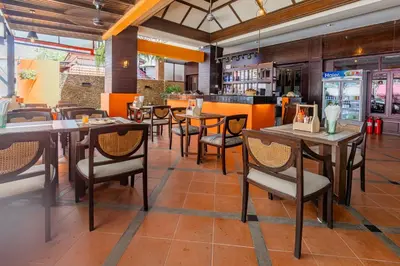 a dining room with tables and chairs in a restaurant at Rattana Karon Beach Hotel in Karon Beach