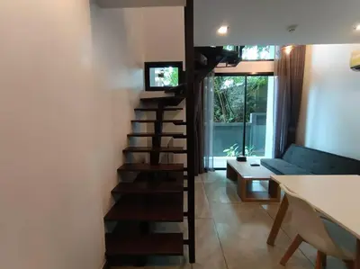 a spiral staircase in a living room with a couch at Utopia Naiharn - Room3 - B124 in Rawai Beach