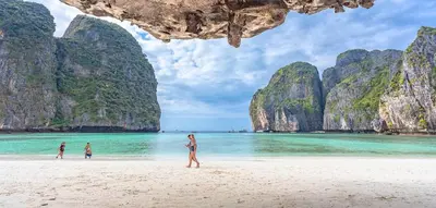 a group of people walking on a beach with limestone cliffs at XX Bao Patong Beach PHUKET เบา หาดป่าตอง ภูเก็ต in Patong Beach