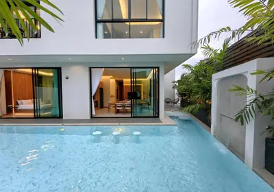 a house with a swimming pool in front of it at Bangtao Luxury Pool Villa - PrymaVerde in Laguna Phuket
