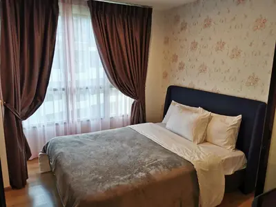 a bedroom with a bed and a window with curtains at Centrio Phuket C3 in Ban Rangeng