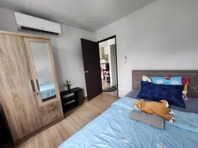 a bedroom with a blue bed with a stuffed animal on it at Centrio Phuket C3 in Ban Rangeng