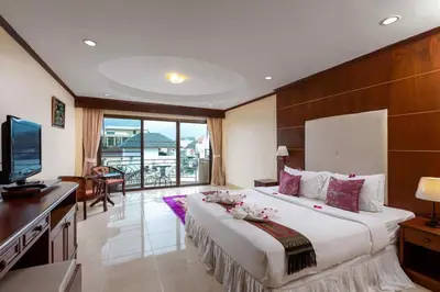 a bedroom with a large bed with a desk and a television at Centre Point Nanai in Patong Beach