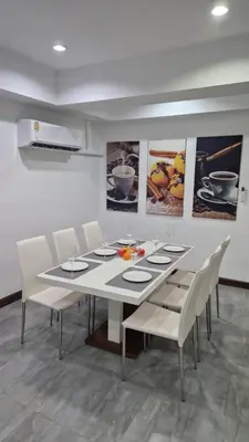 a dining room with a white table and chairs at Two bedroom apartment near Naiharn beach in Nai Harn Beach