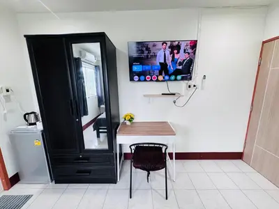 a bathroom with a black cabinet and a tv on the wall at KLApartment in Ban Bang Chak
