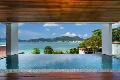an infinity pool with a view of the ocean at Patong WiN HOUSE Villa in Patong Beach