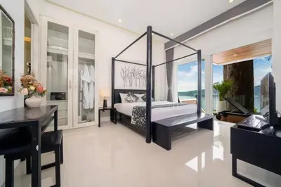 a bedroom with a bed and a desk at Patong WiN HOUSE Villa in Patong Beach
