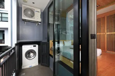 a bathroom with a washing machine in a room at Relife Windy B226 at NaiHarn beach by CapitalPro in Phuket Town