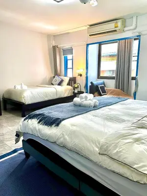 a hotel room with two beds and a window at Comfort Home Patong in Patong Beach