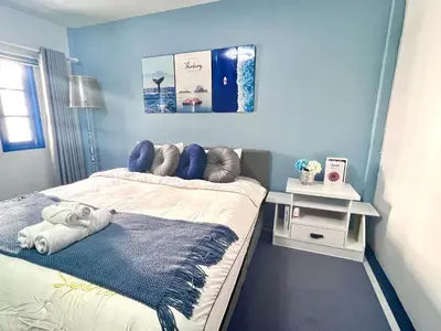 a bedroom with a bed with a blue wall at Comfort Home Patong in Patong Beach