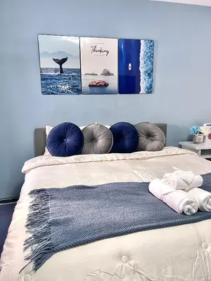 a bed with three pictures on the wall at Comfort Home Patong in Patong Beach