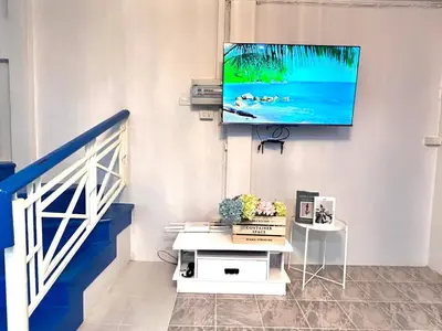 a living room with a tv on a wall at Comfort Home Patong in Patong Beach