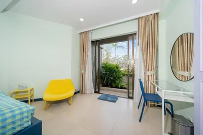 a room with a bed and a table and chairs at Allamanda Laguna Phuket in Laguna Phuket