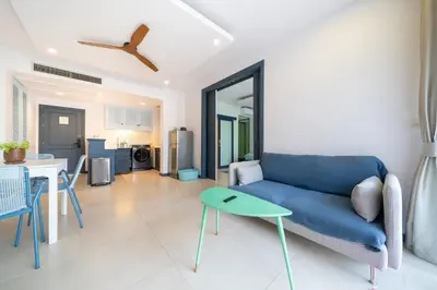 a living room with a blue couch and a table at Allamanda Laguna Phuket in Laguna Phuket