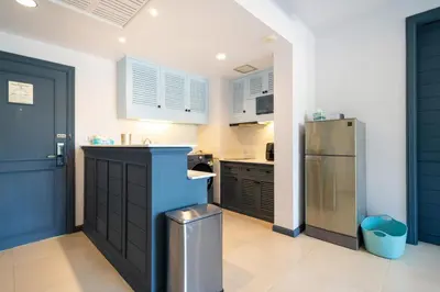 a kitchen with blue cabinets and a refrigerator at Allamanda Laguna Phuket in Laguna Phuket