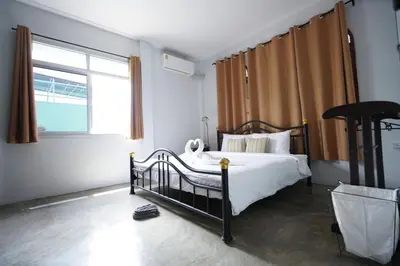 a bedroom with a bed and a large window at Amahostel in Ban Thalat Choeng Thale