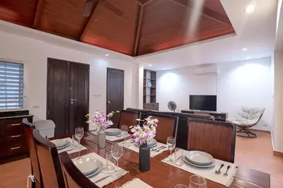 a dining room with a table and a television at Balinese 3BR Pool Villa Freya, Spacious Courtyard, 70 m from Stay Wellbeing & Lifestyle in Rawai Beach