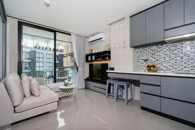 a living room with a couch and a kitchen at Your Relaxing Stay! Suite CTG P506 at Tropics Kamala Residence with Scenic Rooftop Pool and Great Amenities in Kamala Beach