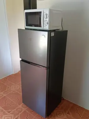 a microwave sitting on top of a refrigerator at Green House 2 in Ban Na Nai