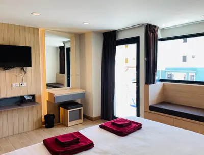 a bedroom with a bed with two red towels on it at Room Actually in Karon Beach
