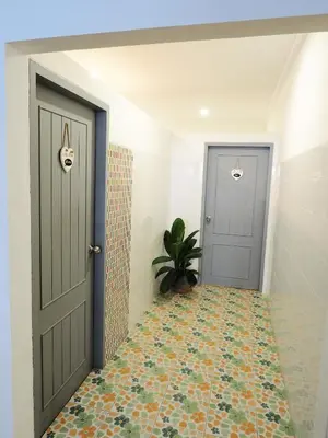 a hallway with two doors and a tile floor at Siri Hotel Phuket in Phuket Town