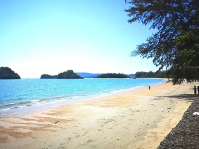a beach with people walking on the sand and water at Successive BeachFront ,Krabi in Ban Khlong Haeng