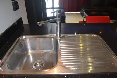 a stainless steel sink with a faucet in a kitchen at Absolute Bangla Suites 69sqm with Jacuzzi in Patong Beach