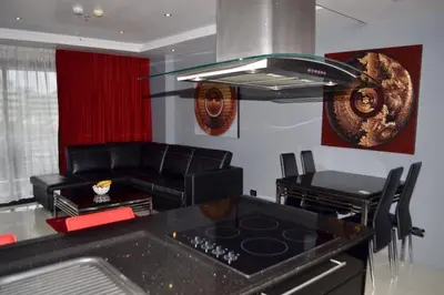 a kitchen with a stove and a living room at Absolute Bangla Suites 69sqm with Jacuzzi in Patong Beach